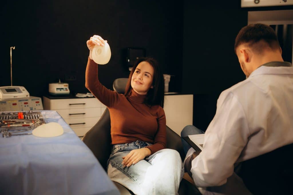 a woman talks to a surgeon about the size and shape of breast implants